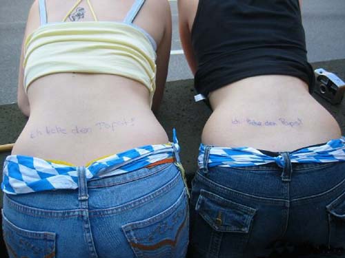 Pro-Pope tattoos on two girls lower backs